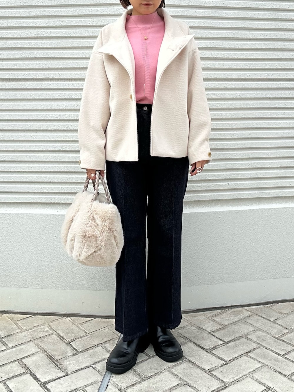 ピンク系のニット/セーター、ホワイト系のテーラードジャケットを着用したレディースの秋コーディネートの2枚目の写真