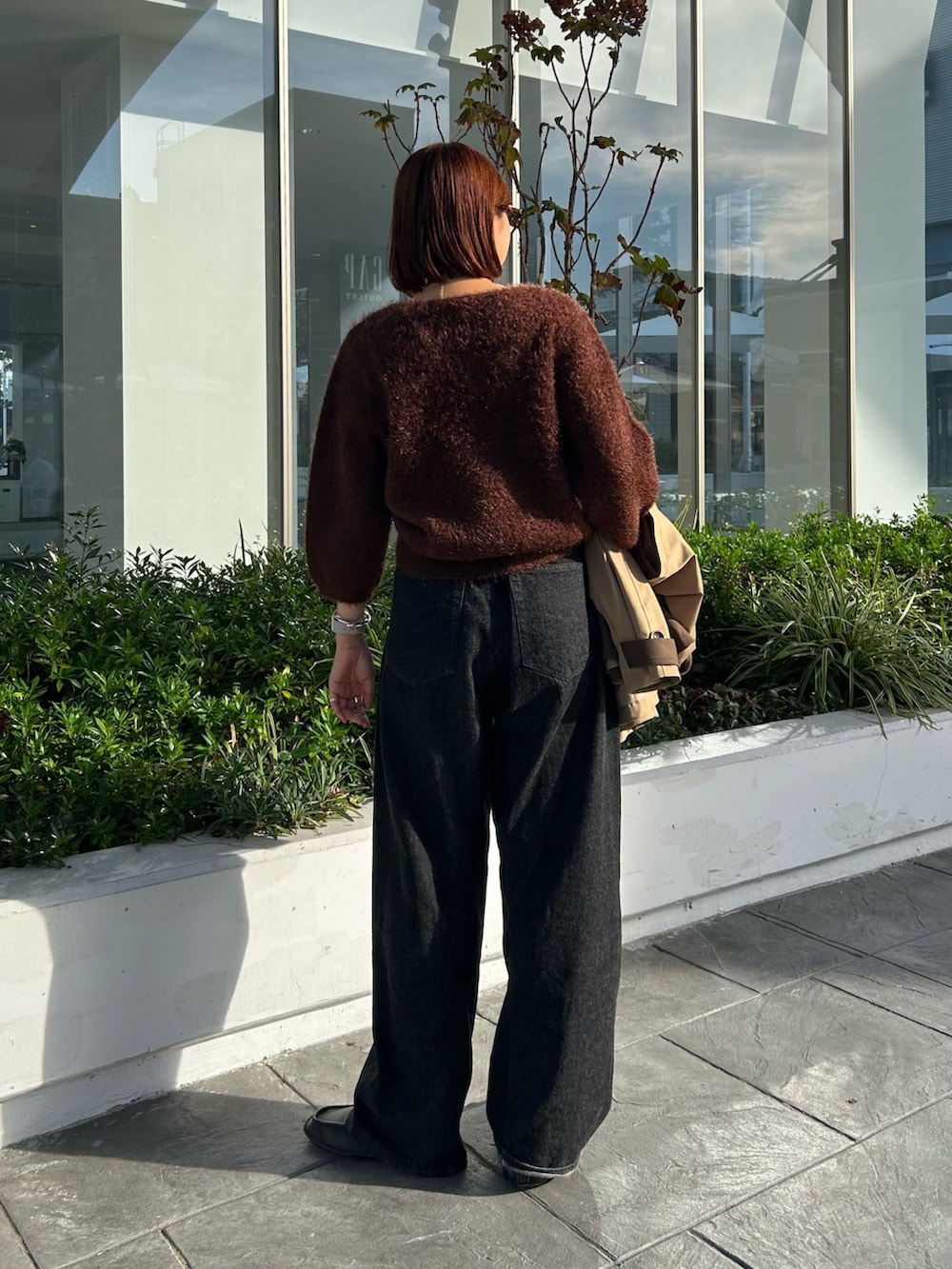 ブラウン系のニット/セーターを着用したレディースの秋コーディネートの2枚目の写真