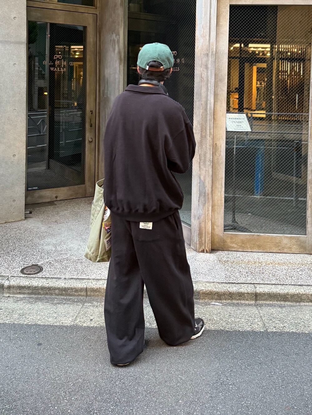 ブラック系のスウェット、ブラック系のスウェットパンツ、グリーン系のトートバッグを着用したメンズの秋コーディネートの3枚目の写真