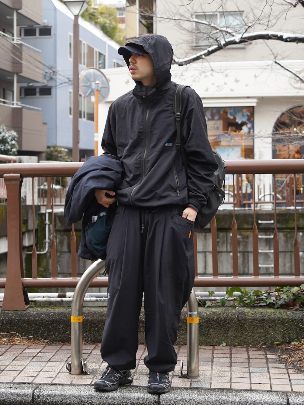 ブラック系のマウンテンパーカーを着用したメンズの冬コーディネートの2枚目の写真