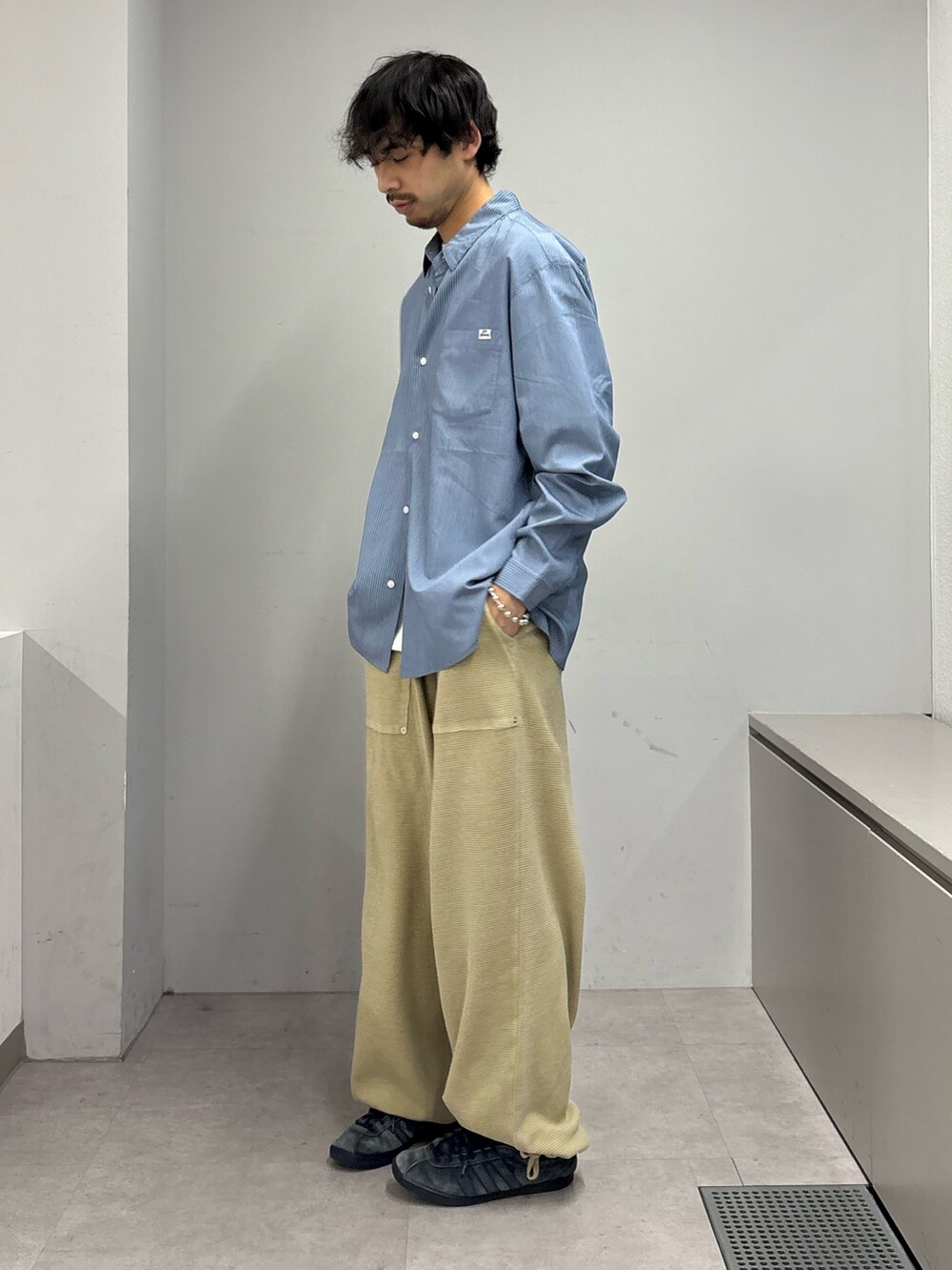 ブルー系のシャツ/ブラウス、ベージュ系のスウェットパンツを着用したメンズの春コーディネートの2枚目の写真