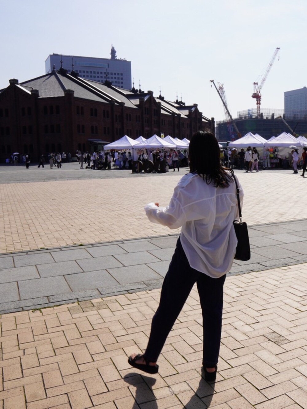 ブラック系のショルダーバッグ、ブルー系のデニムパンツ、ホワイト系のシャツ/ブラウスを着用したレディースの春コーディネートの2枚目の写真