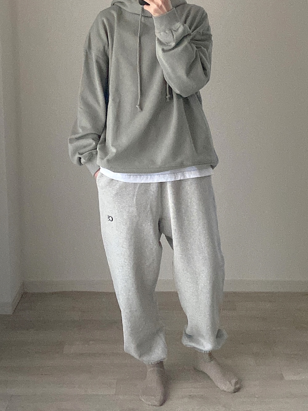 グリーン系のパーカー、グレー系のスウェットパンツを着用したレディースの冬コーディネートの2枚目の写真