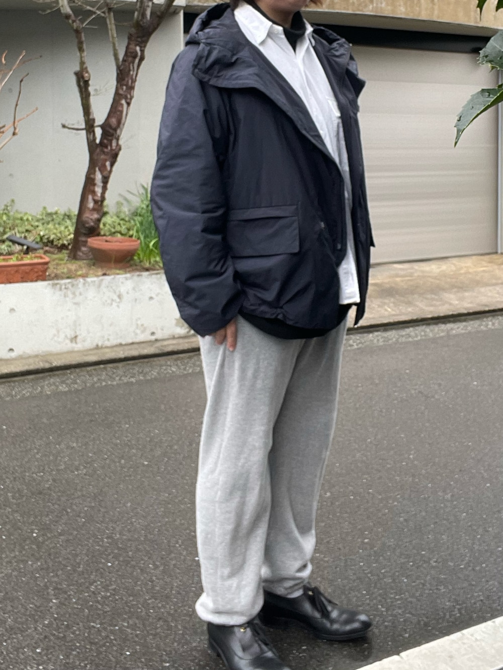 グレー系のスウェットパンツ、ブラック系のドレスシューズ、ブルー系のナイロンジャケットを着用したレディースの冬コーディネートの2枚目の写真