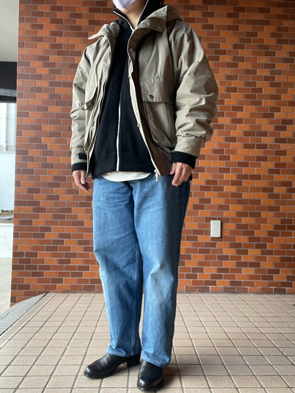 ブラック系のローファー、ブルー系のデニムパンツ、ブラック系のニット/セーターを着用したレディースの冬コーディネートの2枚目の写真