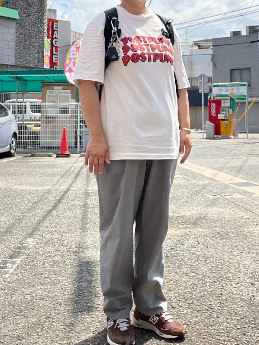 グリーン系のチノパンツ、ブラック系のバックパック/リュック、ホワイト系のTシャツ/カットソーを着用したレディースの夏コーディネートの2枚目の写真