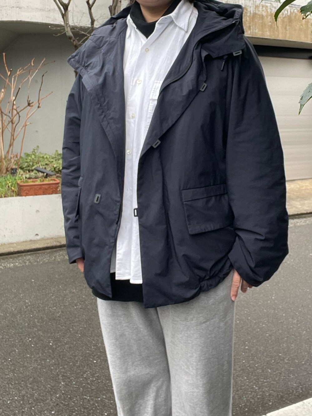 グレー系のスウェットパンツ、ブラック系のドレスシューズ、ブルー系のナイロンジャケットを着用したレディースの冬コーディネートの3枚目の写真