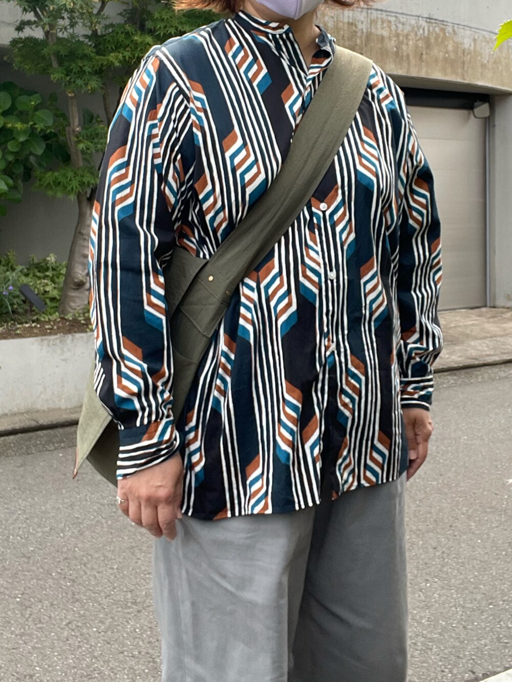 グリーン系のチノパンツ、ブラック系のブーツ、その他のシャツ/ブラウスを着用したレディースの夏コーディネートの3枚目の写真