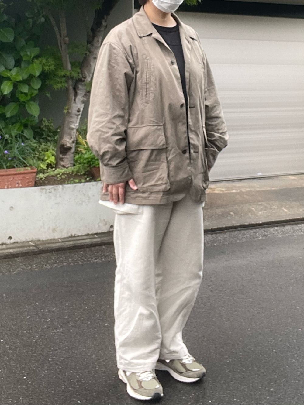 ホワイト系のカーゴパンツ、ベージュ系のカバーオール、グリーン系のスニーカーを着用したレディースの春コーディネートの3枚目の写真