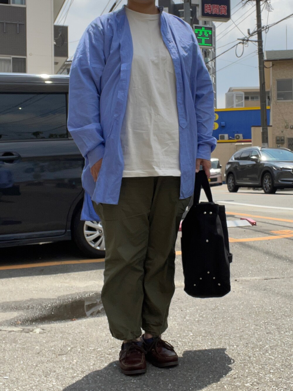 ブルー系のショルダーバッグ、ブルー系のシャツ/ブラウス、グリーン系のカーゴパンツを着用したレディースの春コーディネートの2枚目の写真