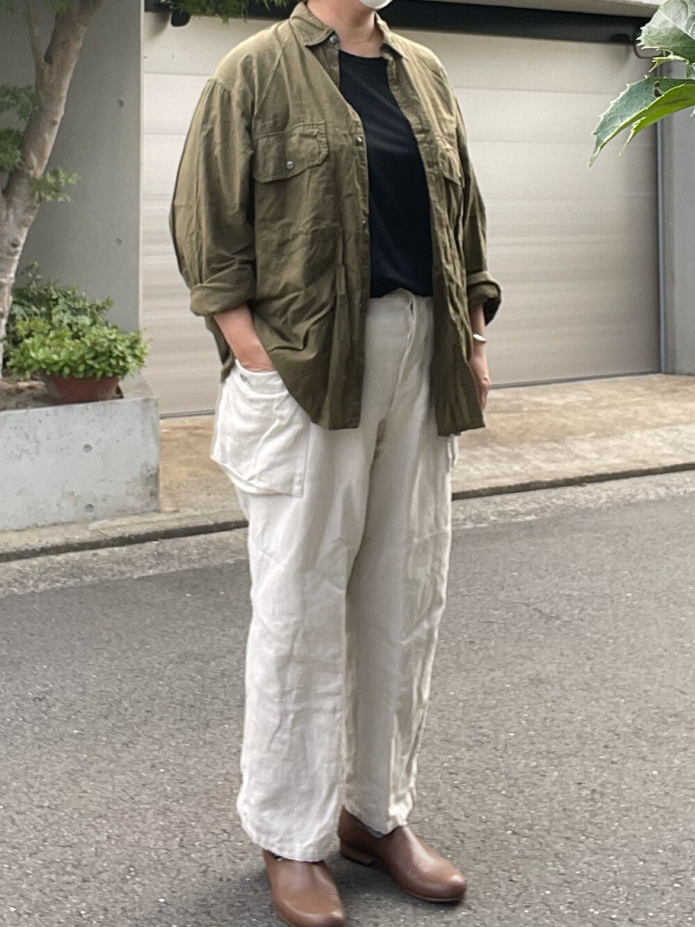 ブラウン系のローファー、ホワイト系のカーゴパンツ、グリーン系のシャツ/ブラウスを着用したレディースの夏コーディネートの2枚目の写真
