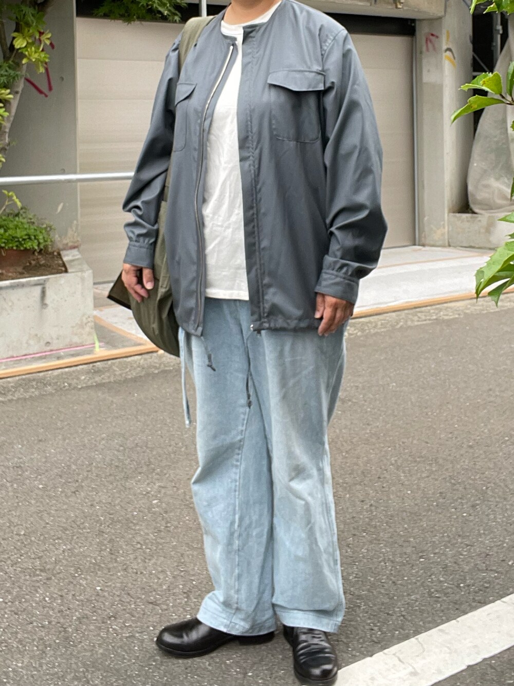 ブルー系のデニムパンツ、シルバー系のシャツ/ブラウス、グリーン系のショルダーバッグを着用したレディースの夏コーディネートの3枚目の写真