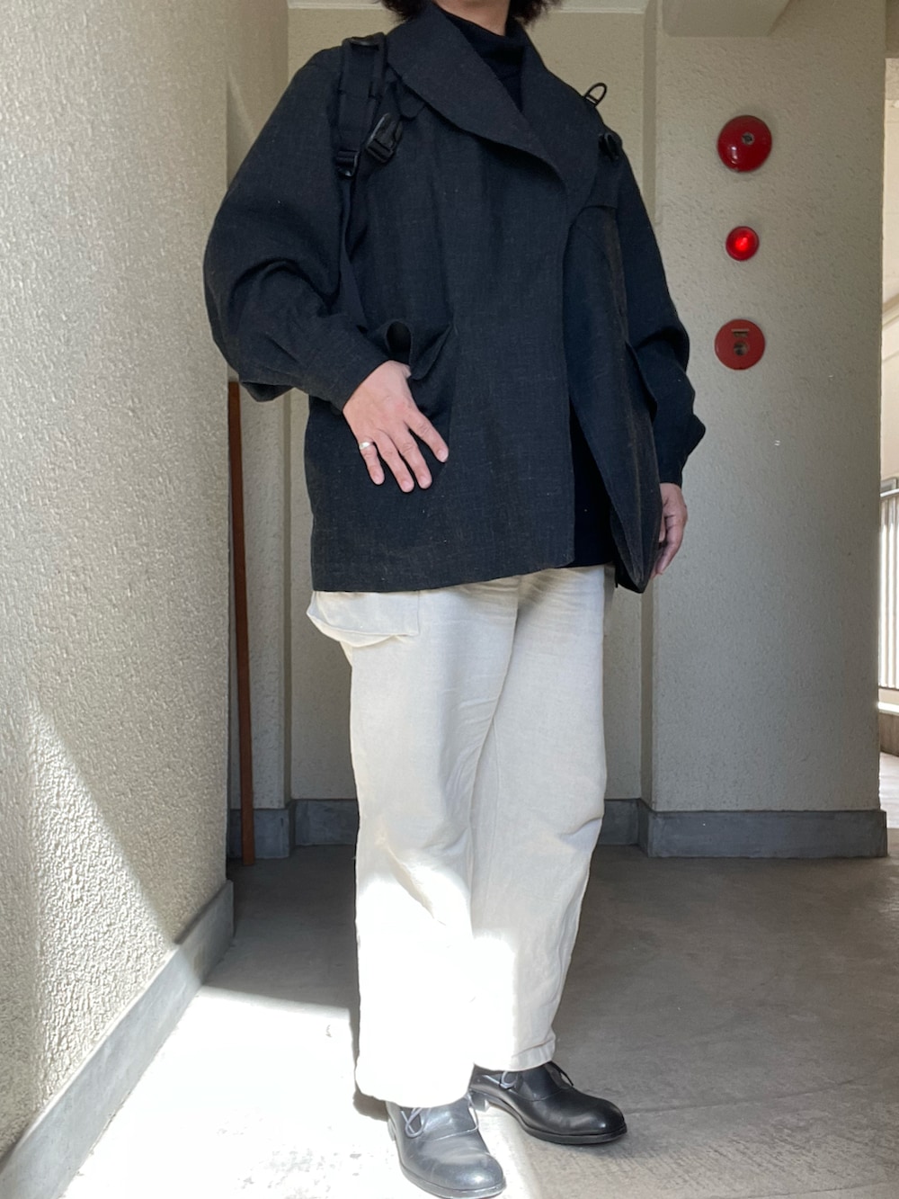 ホワイト系のカーゴパンツ、グレー系のジャケット/アウター、ブラック系のTシャツ/カットソーを着用したレディースの冬コーディネートの2枚目の写真