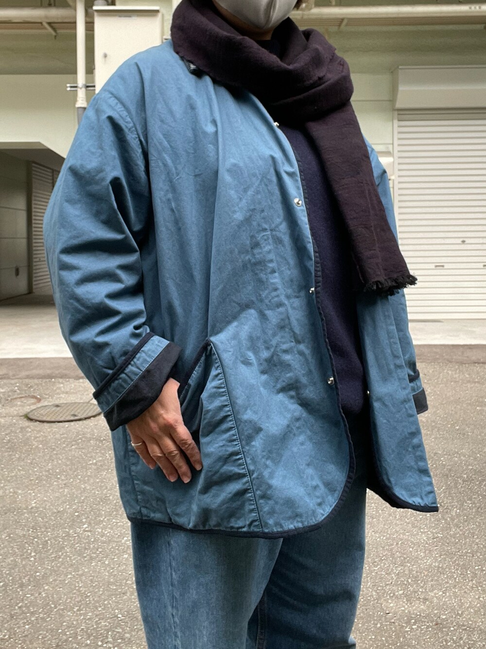 ブラック系のドレスシューズ、ブルー系のデニムパンツ、ブルー系のカバーオールを着用したレディースの冬コーディネートの3枚目の写真