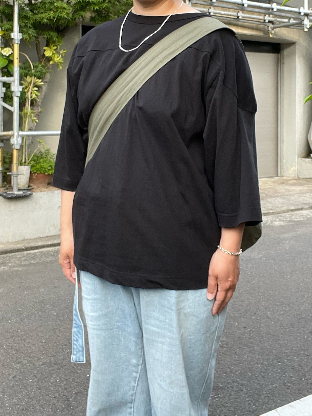 ブルー系のデニムパンツ、ブラウン系のローファー、ブラック系のTシャツ/カットソーを着用したレディースの夏コーディネートの2枚目の写真
