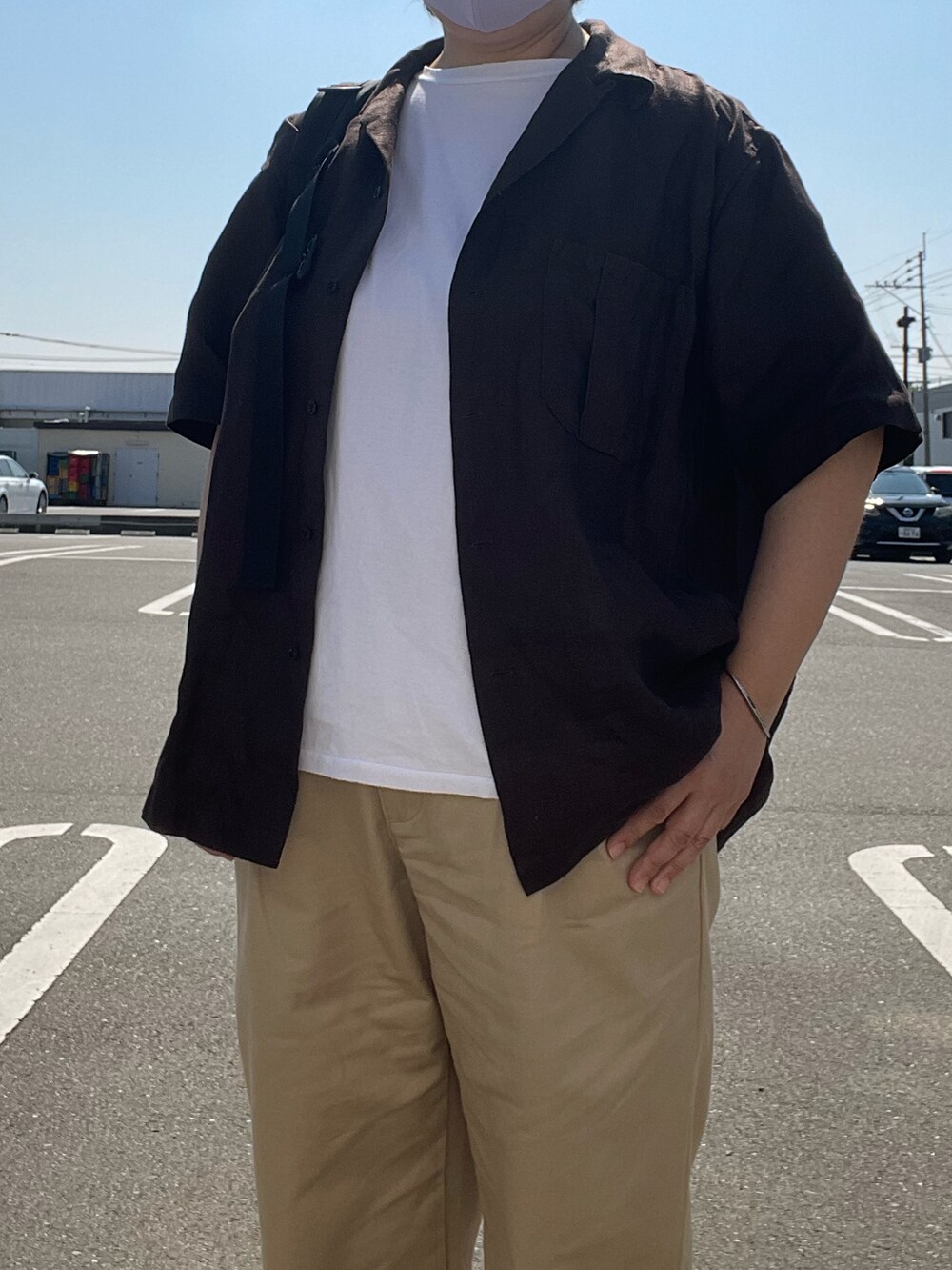 ブラウン系のシャツ/ブラウス、ベージュ系のチノパンツ、ホワイト系のTシャツ/カットソーを着用したレディースの夏コーディネートの3枚目の写真