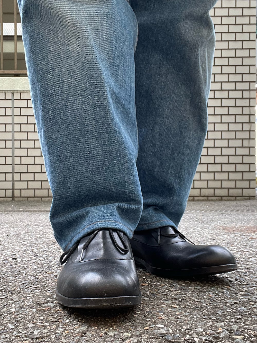 ブラック系のドレスシューズ、ブルー系のデニムパンツ、ブルー系のカバーオールを着用したレディースの冬コーディネートの4枚目の写真