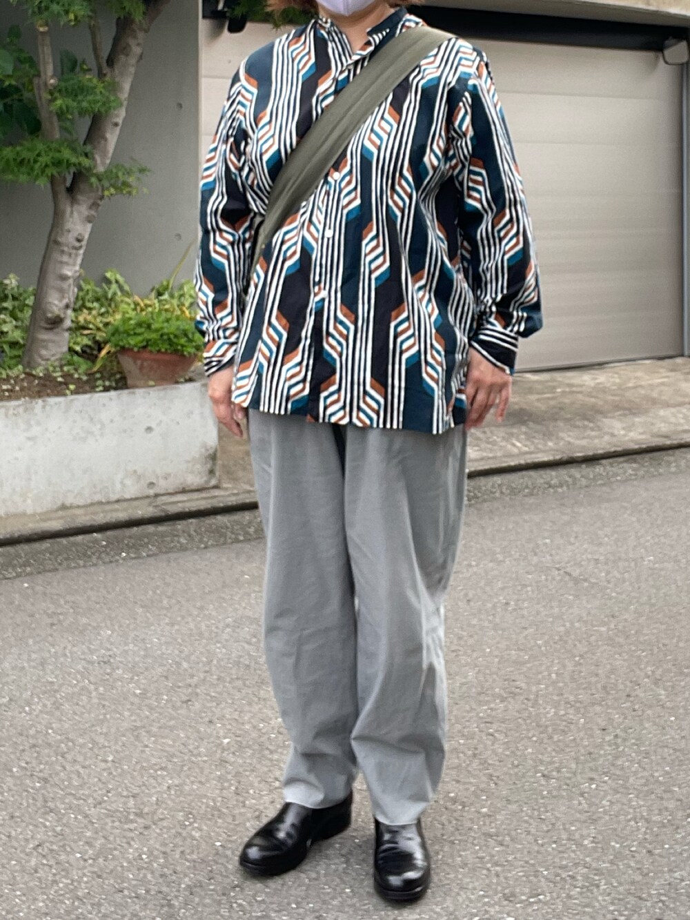 グリーン系のチノパンツ、ブラック系のブーツ、その他のシャツ/ブラウスを着用したレディースの夏コーディネートの2枚目の写真