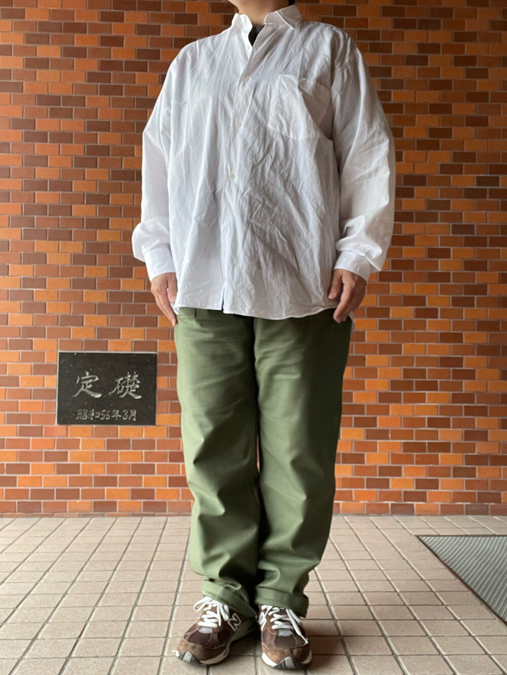 グリーン系のパンツ、ブラウン系のスニーカー、ホワイト系のシャツ/ブラウスを着用したレディースの秋コーディネートの3枚目の写真