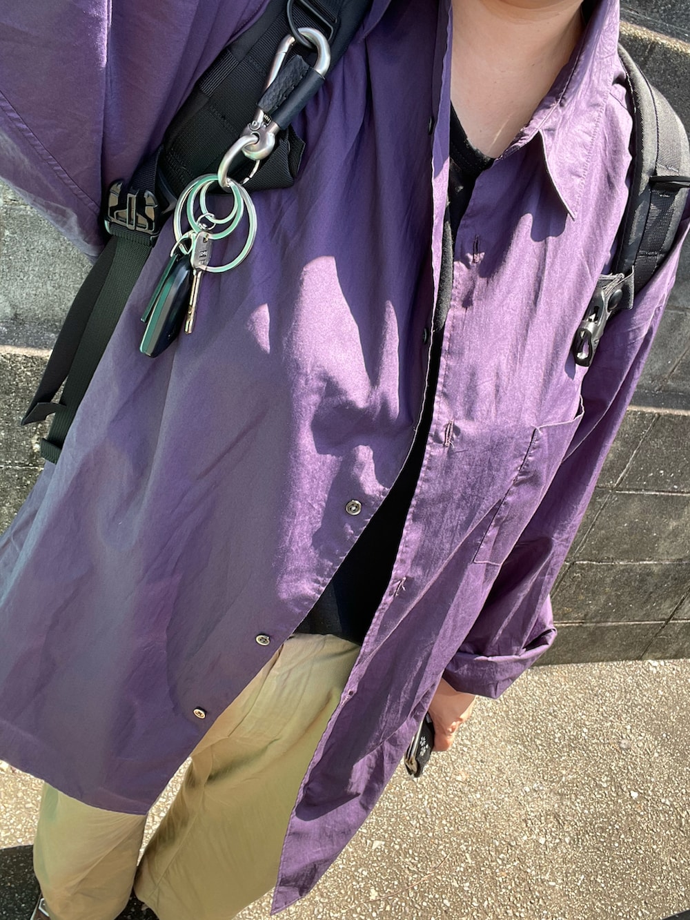 パープル系のシャツ/ブラウス、ブラック系のTシャツ/カットソー、ベージュ系のチノパンツを着用したレディースの秋コーディネートの4枚目の写真