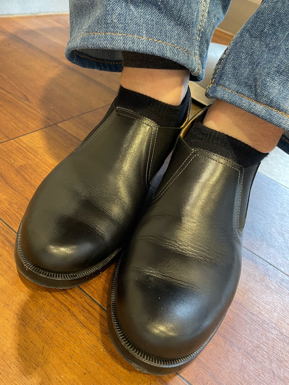 ブラック系のローファー、ブルー系のデニムパンツ、ブラック系のニット/セーターを着用したレディースの冬コーディネートの5枚目の写真