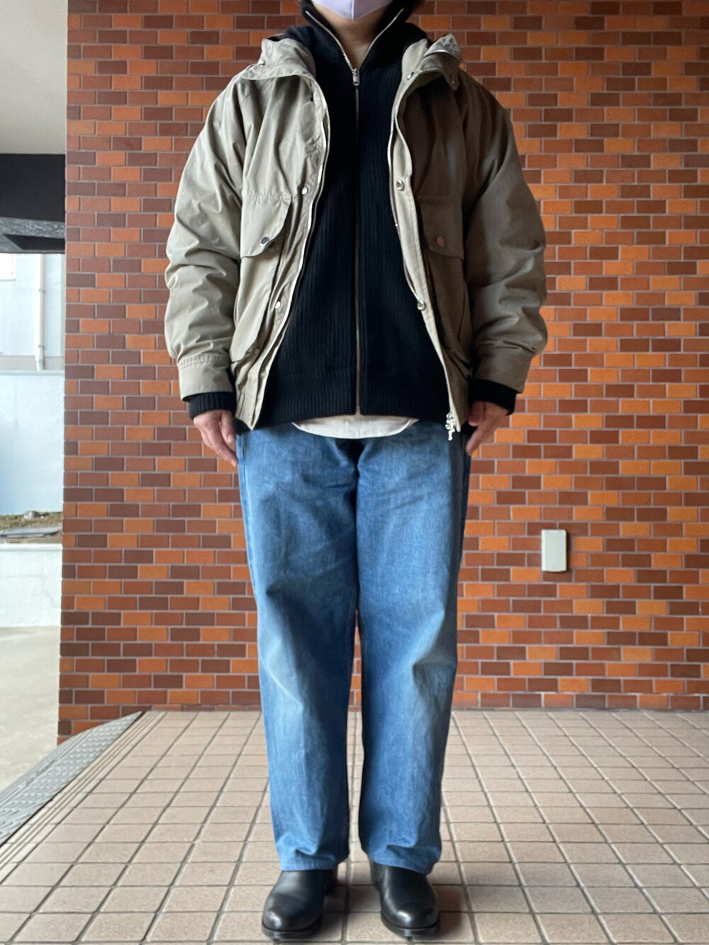 ブラック系のローファー、ブルー系のデニムパンツ、ブラック系のニット/セーターを着用したレディースの冬コーディネートの3枚目の写真