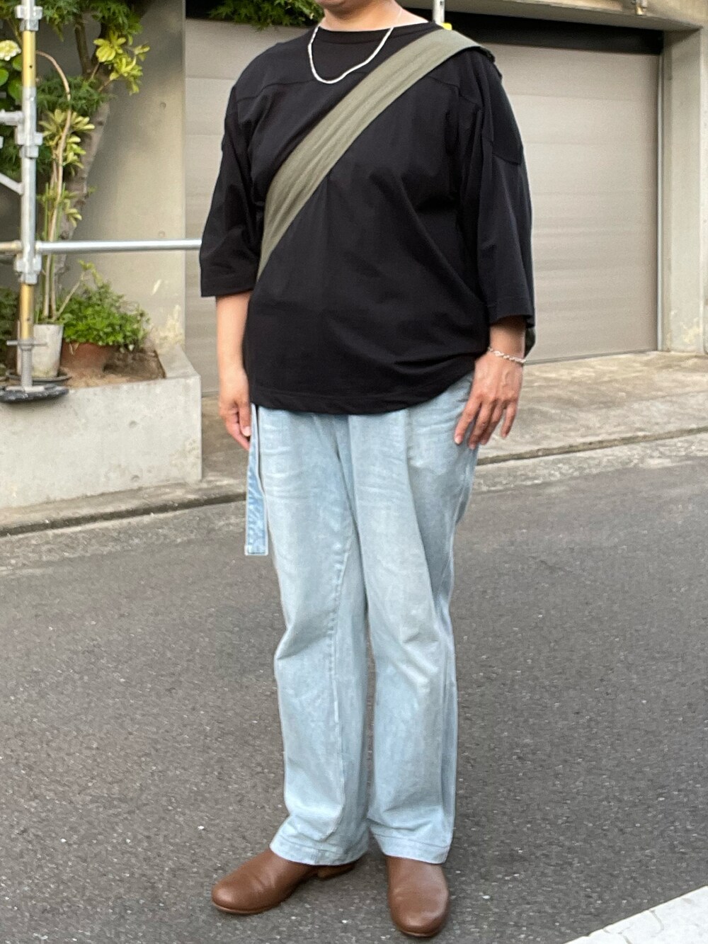 ブルー系のデニムパンツ、ブラウン系のローファー、ブラック系のTシャツ/カットソーを着用したレディースの夏コーディネートの3枚目の写真