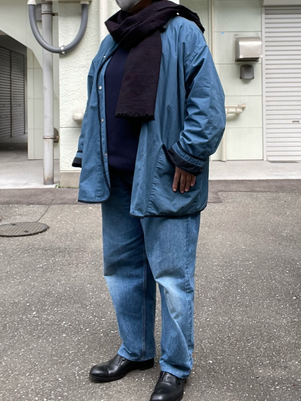 ブラック系のドレスシューズ、ブルー系のデニムパンツ、ブルー系のカバーオールを着用したレディースの冬コーディネートの2枚目の写真