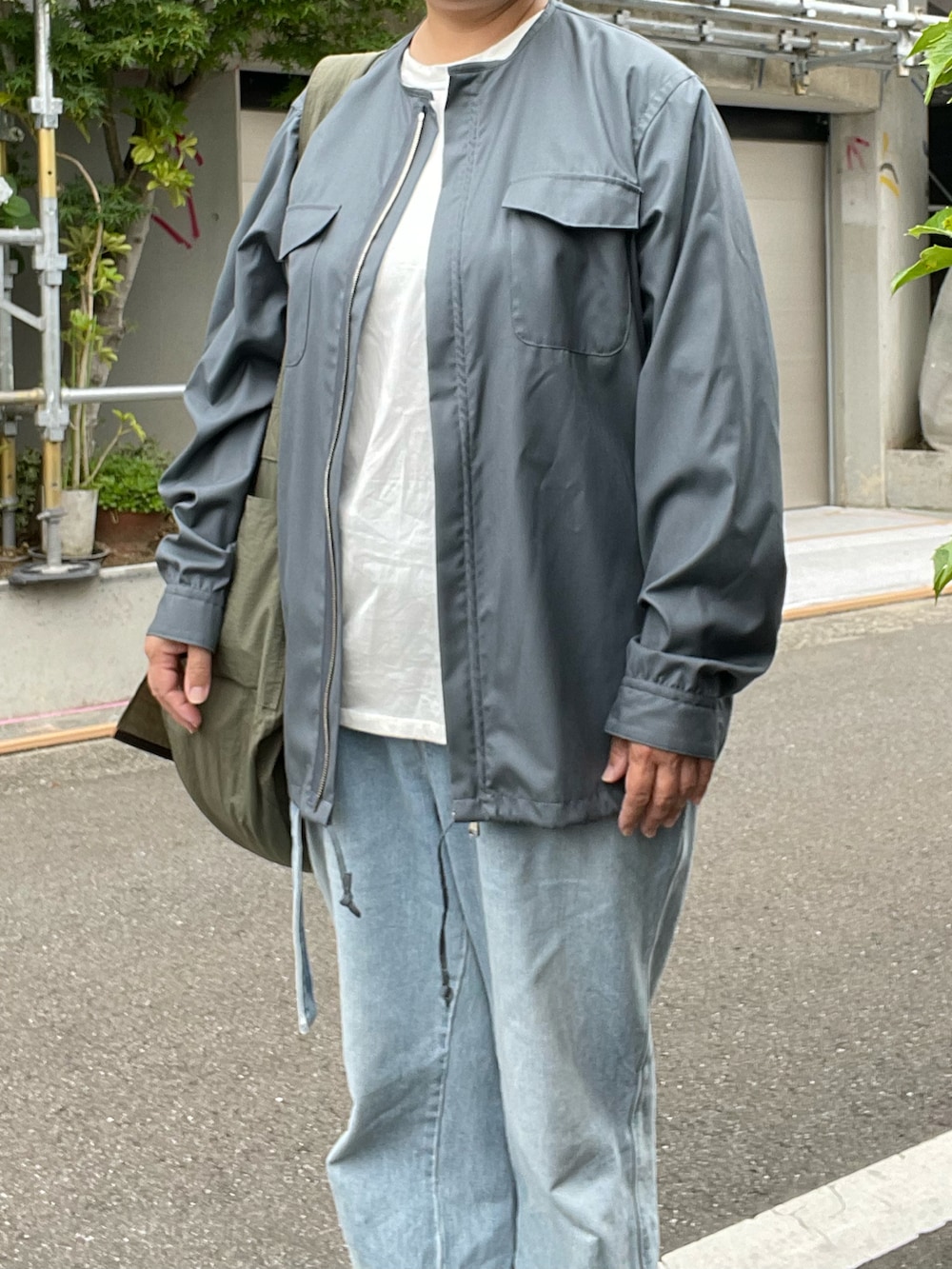 ブルー系のデニムパンツ、シルバー系のシャツ/ブラウス、グリーン系のショルダーバッグを着用したレディースの夏コーディネートの2枚目の写真