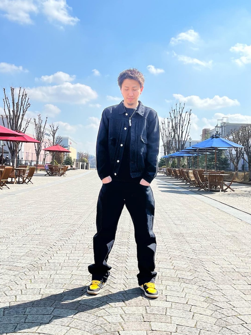 イエロー系のスニーカー、ブラック系のデニムパンツ、ブラック系のデニムジャケットを着用したメンズの春コーディネートの2枚目の写真