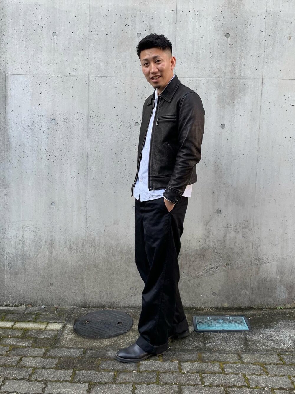 ブラック系のステンカラーコート、ホワイト系のシャツ/ブラウス、ブラック系のチノパンツを着用したメンズの冬コーディネートの2枚目の写真