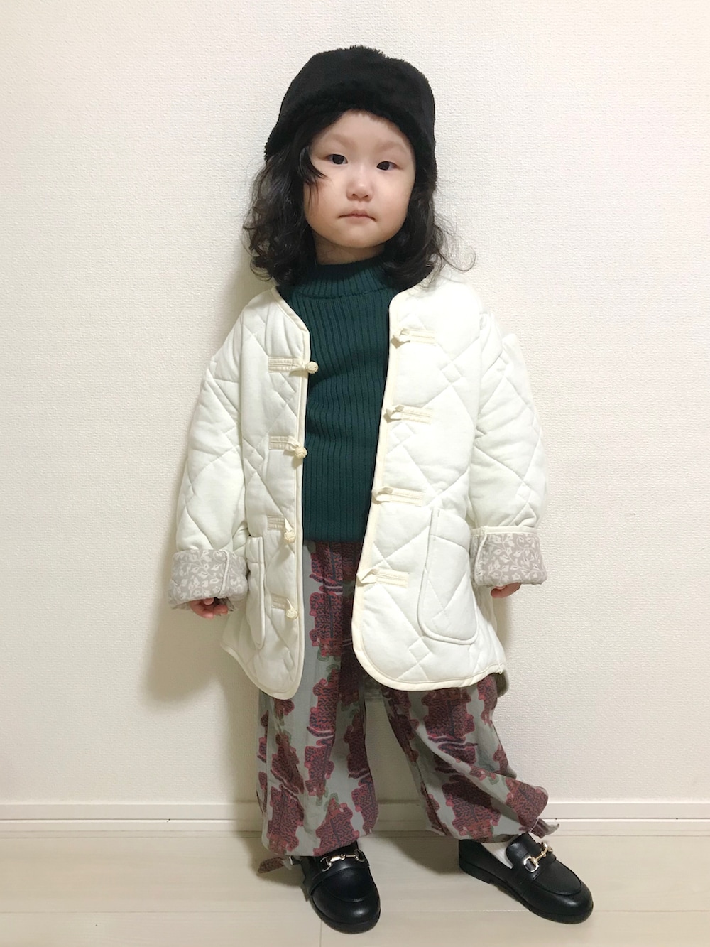 ホワイト系のブルゾン、グリーン系のニット/セーター、グレー系のその他パンツを着用したキッズの秋コーディネートの2枚目の写真