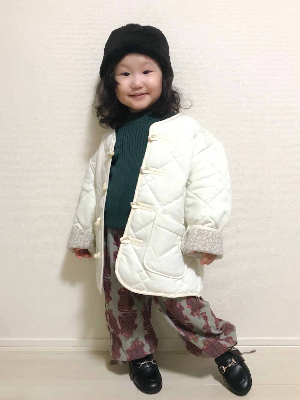 ホワイト系のブルゾン、グリーン系のニット/セーター、グレー系のその他パンツを着用したキッズの秋コーディネートの3枚目の写真