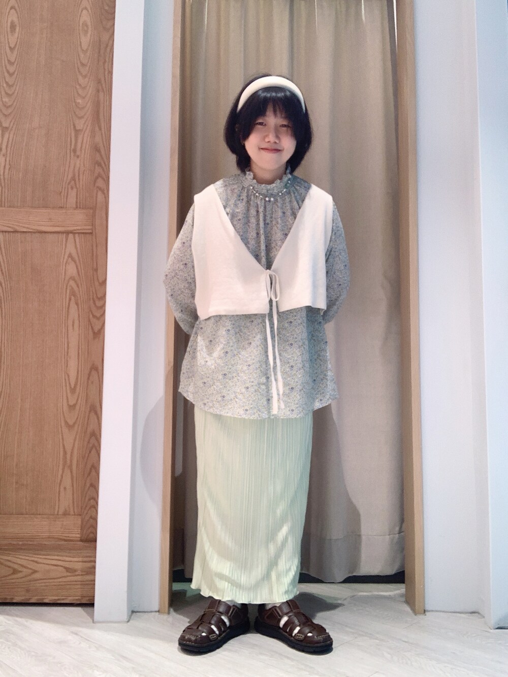 グリーン系のトップスを着用したレディースの夏コーディネートの2枚目の写真