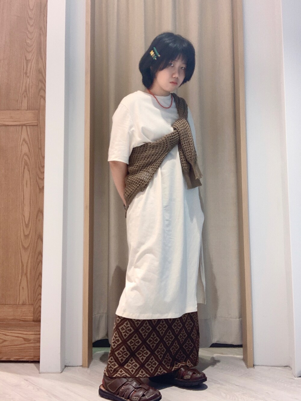 ベージュ系のトップスを着用したレディースの夏コーディネートの2枚目の写真