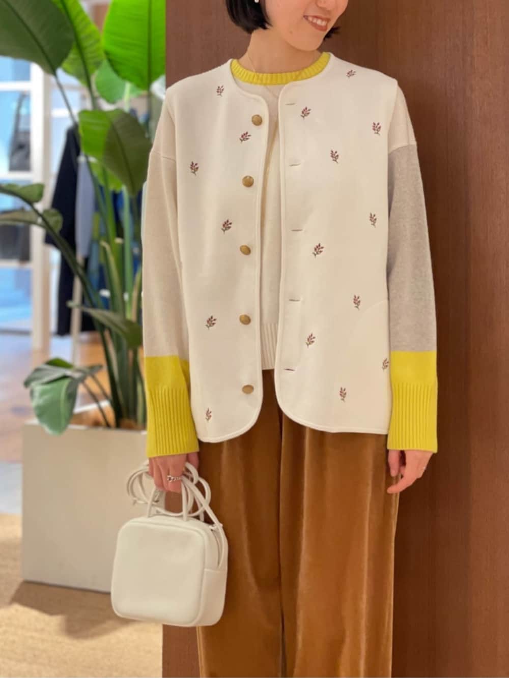 ベージュ系のパンプス、ホワイト系のベスト、ホワイト系のニット/セーターを着用したレディースの秋コーディネートの3枚目の写真