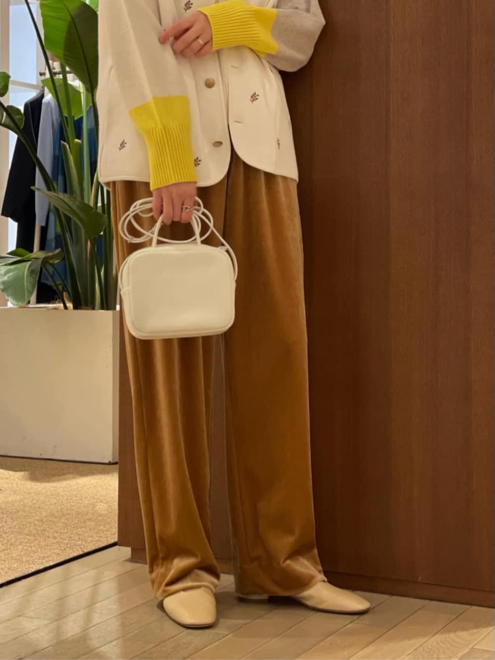 ベージュ系のパンプス、ホワイト系のベスト、ホワイト系のニット/セーターを着用したレディースの秋コーディネートの4枚目の写真