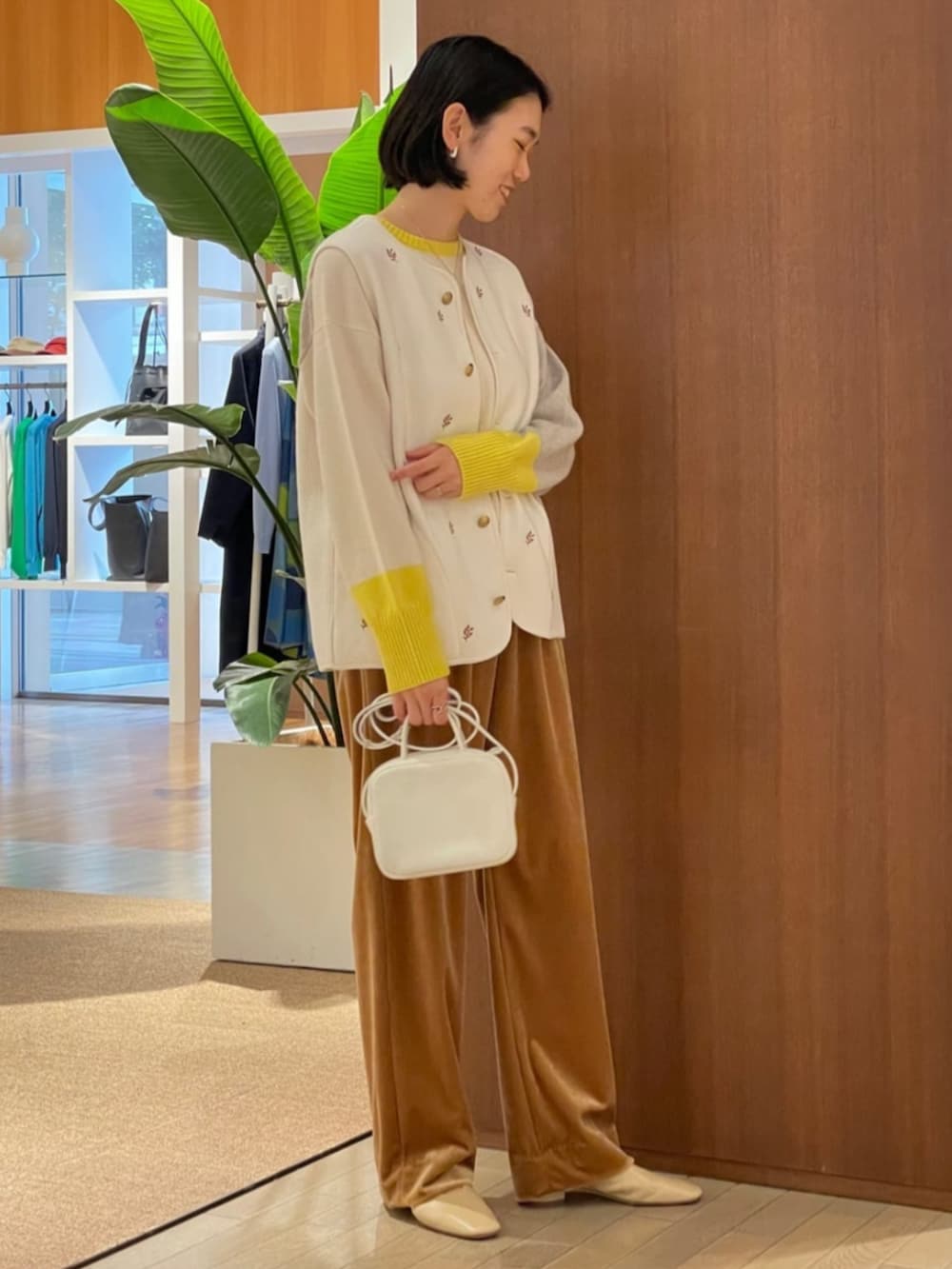 ベージュ系のパンプス、ホワイト系のベスト、ホワイト系のニット/セーターを着用したレディースの秋コーディネートの2枚目の写真