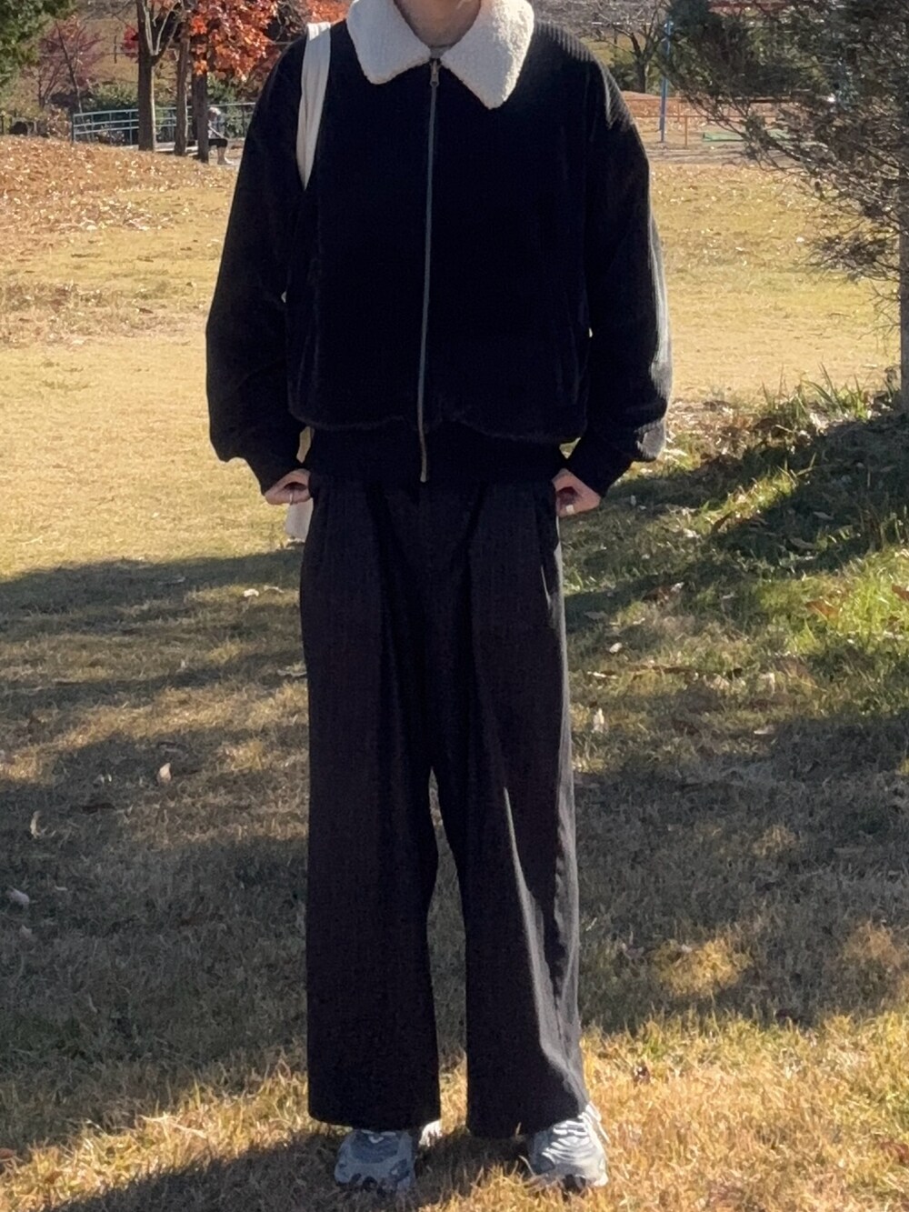 ブラック系のブルゾン、グレー系のスニーカーを着用したメンズの冬コーディネートの2枚目の写真