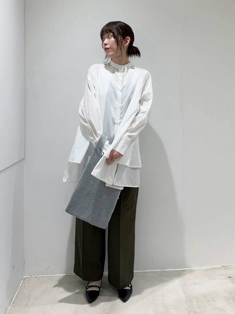 ブラック系のパンプス、グリーン系のその他パンツ、シルバー系のトートバッグを着用したレディースの秋コーディネートの2枚目の写真