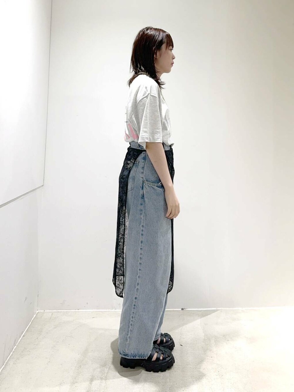 ブルー系のデニムパンツ、グレー系のTシャツ/カットソー、ブラック系のスカートを着用したレディースの夏コーディネートの2枚目の写真