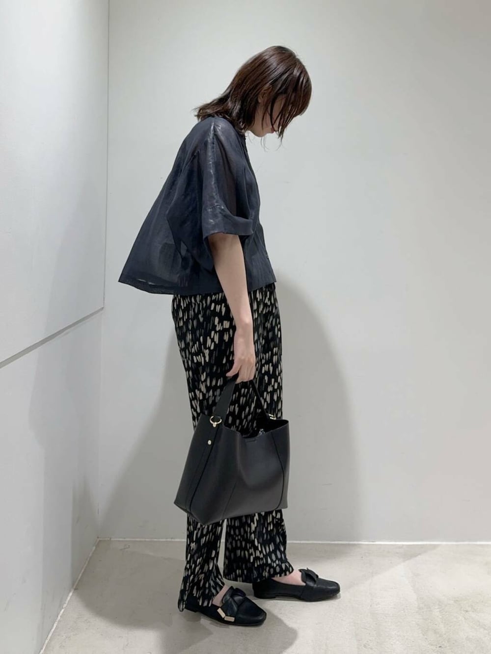 ブラック系のトートバッグ、ブラック系のキャミソール、ブラック系のドレスシューズを着用したレディースの夏コーディネートの2枚目の写真