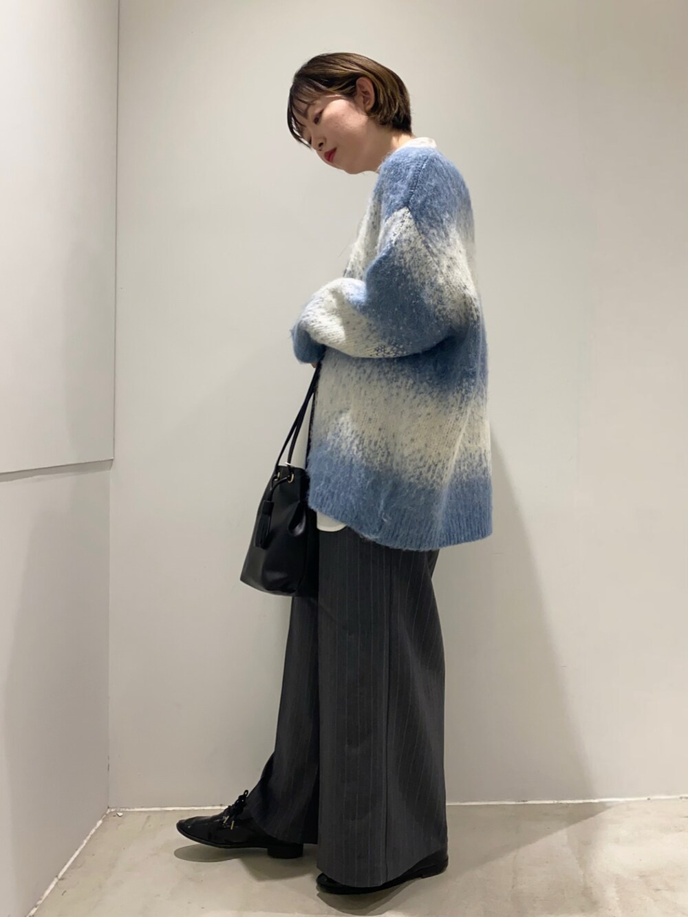 ホワイト系のシャツ/ブラウス、ブラック系のショルダーバッグ、ブルー系のカーディガン/ボレロを着用したレディースの秋コーディネートの4枚目の写真