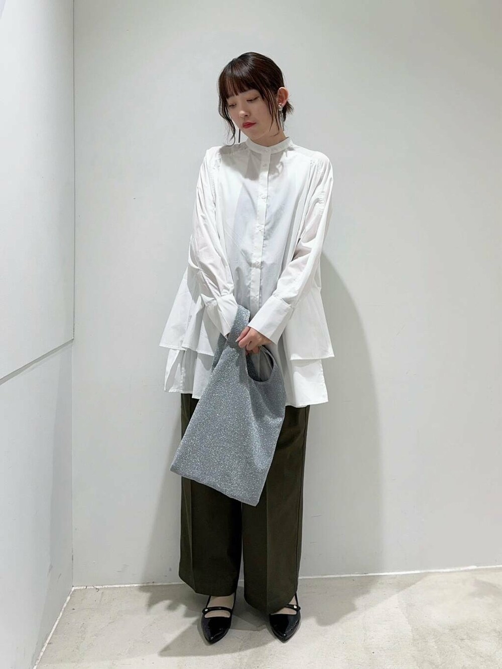 ブラック系のパンプス、グリーン系のその他パンツ、シルバー系のトートバッグを着用したレディースの秋コーディネートの3枚目の写真