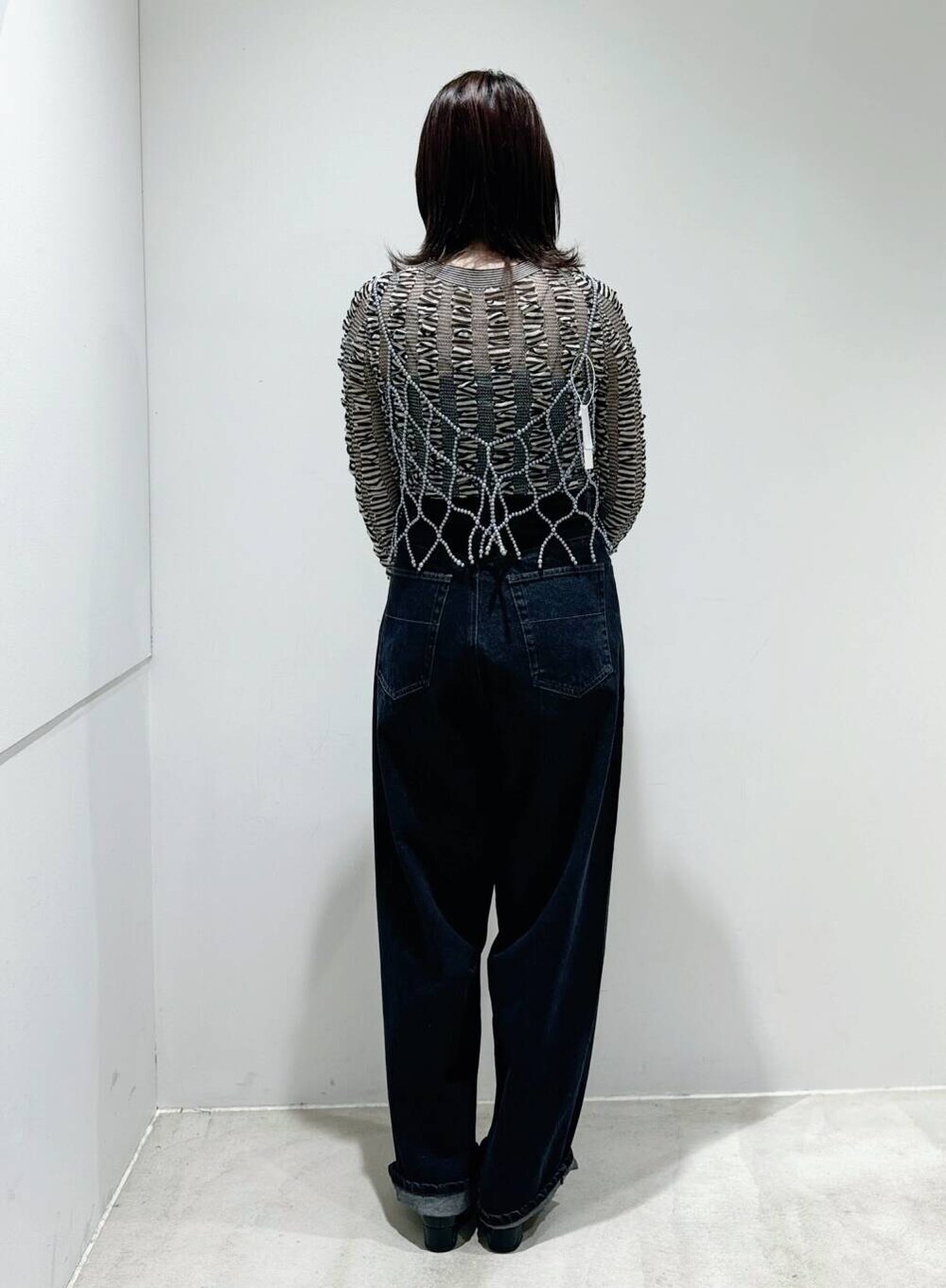 ブラック系のパンプス、ブラック系のデニムパンツ、ブラック系のニット/セーターを着用したレディースの夏コーディネートの3枚目の写真