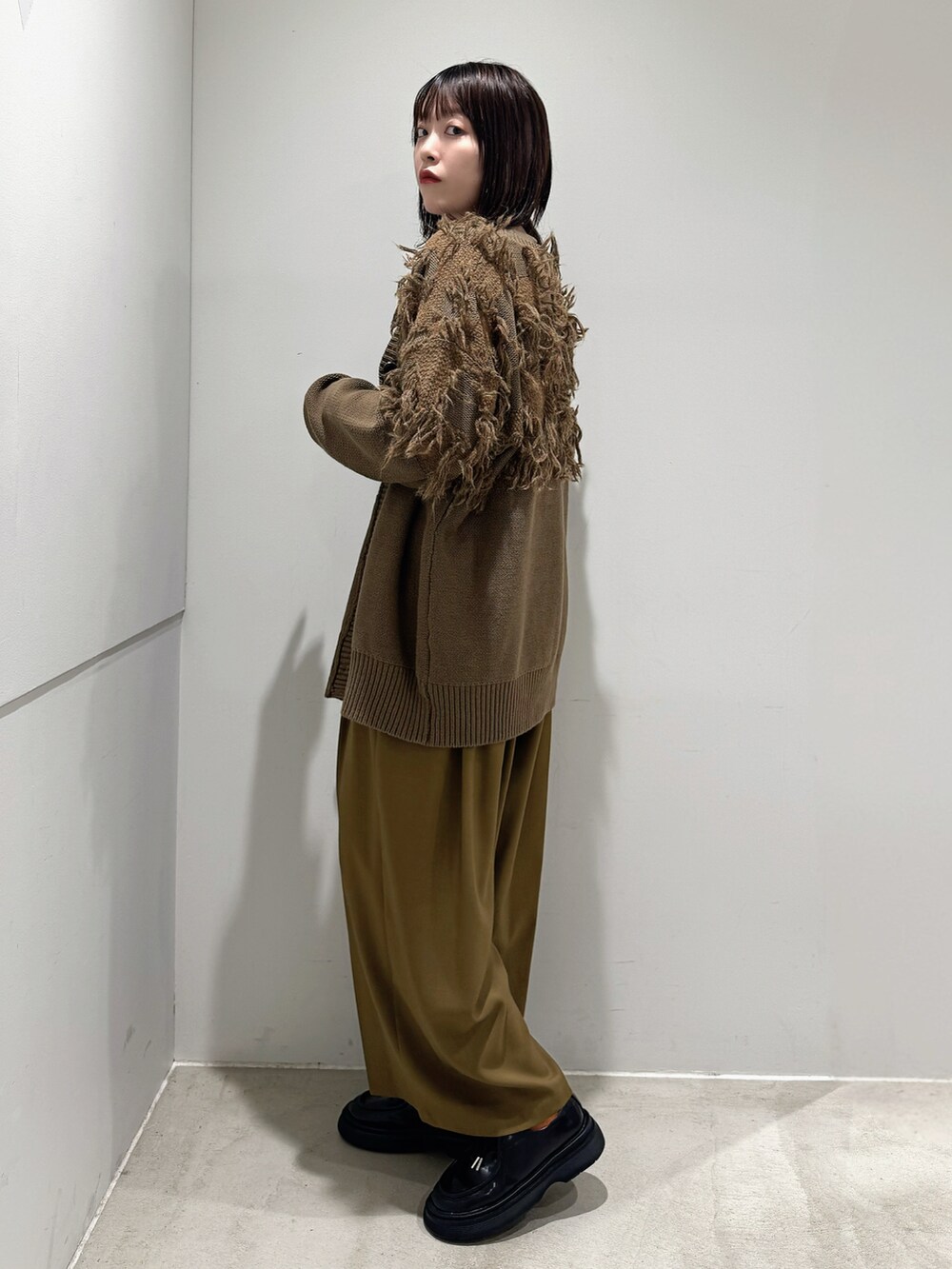 グリーン系のカーディガン/ボレロ、ベージュ系のTシャツ/カットソー、ベージュ系のその他パンツを着用したレディースの秋コーディネートの2枚目の写真