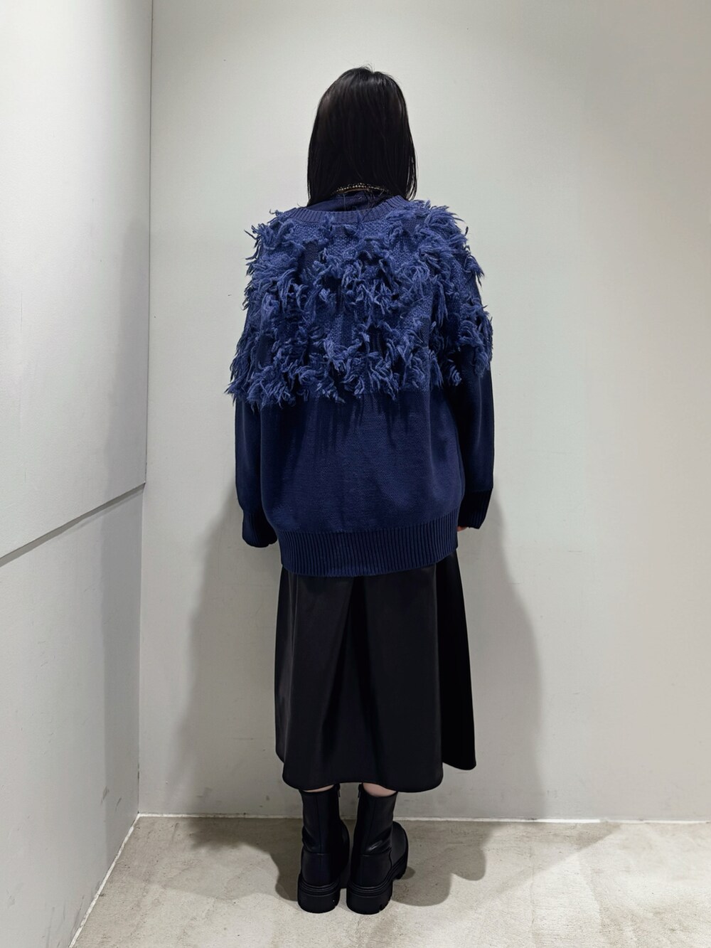 ブルー系のニット/セーター、ブルー系のカーディガン/ボレロ、ブラック系のスカートを着用したレディースの秋コーディネートの3枚目の写真