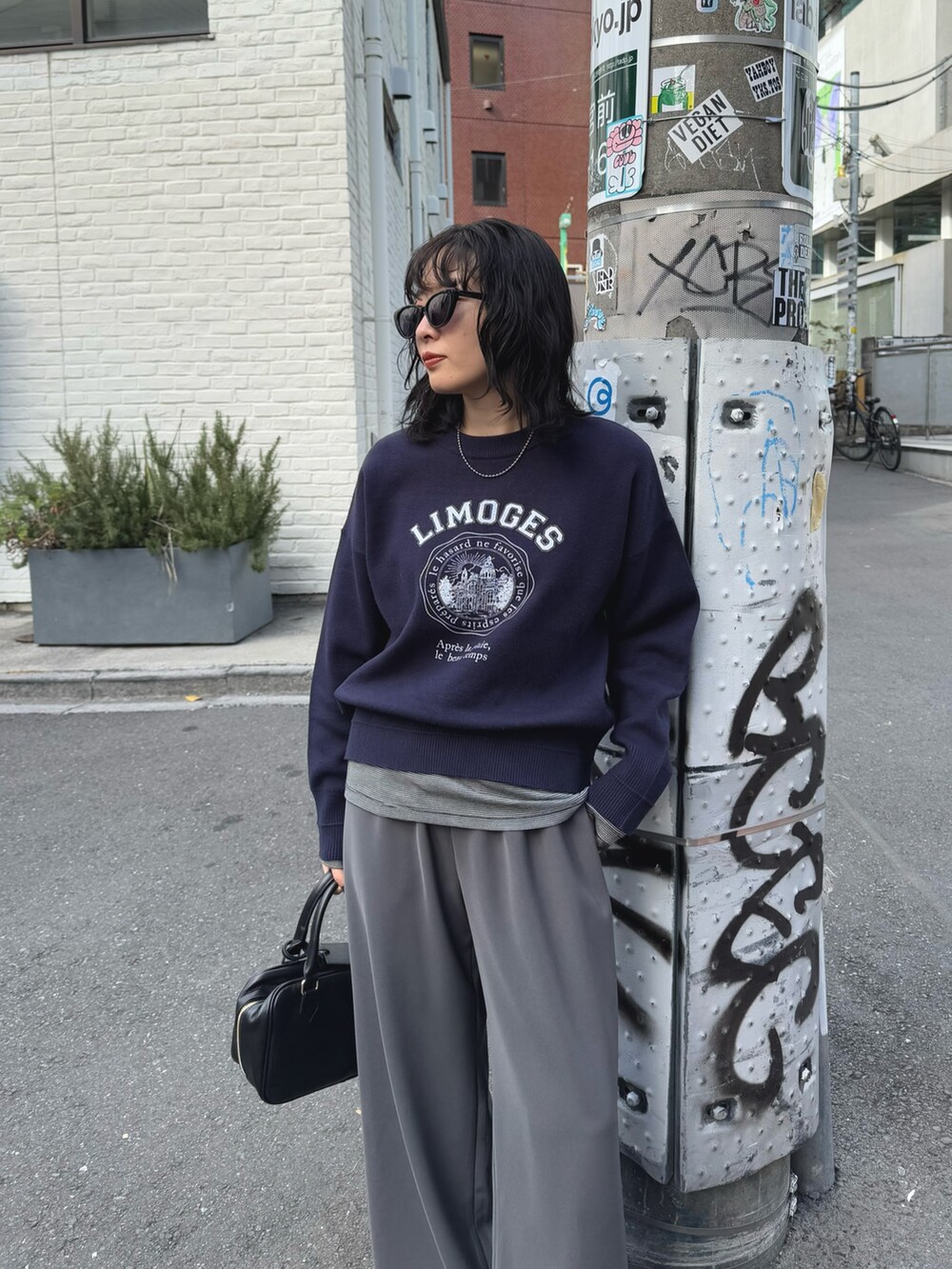 ブルー系のニット/セーター、グレー系のその他パンツ、ブラック系のハンドバッグを着用したレディースの冬コーディネートの4枚目の写真