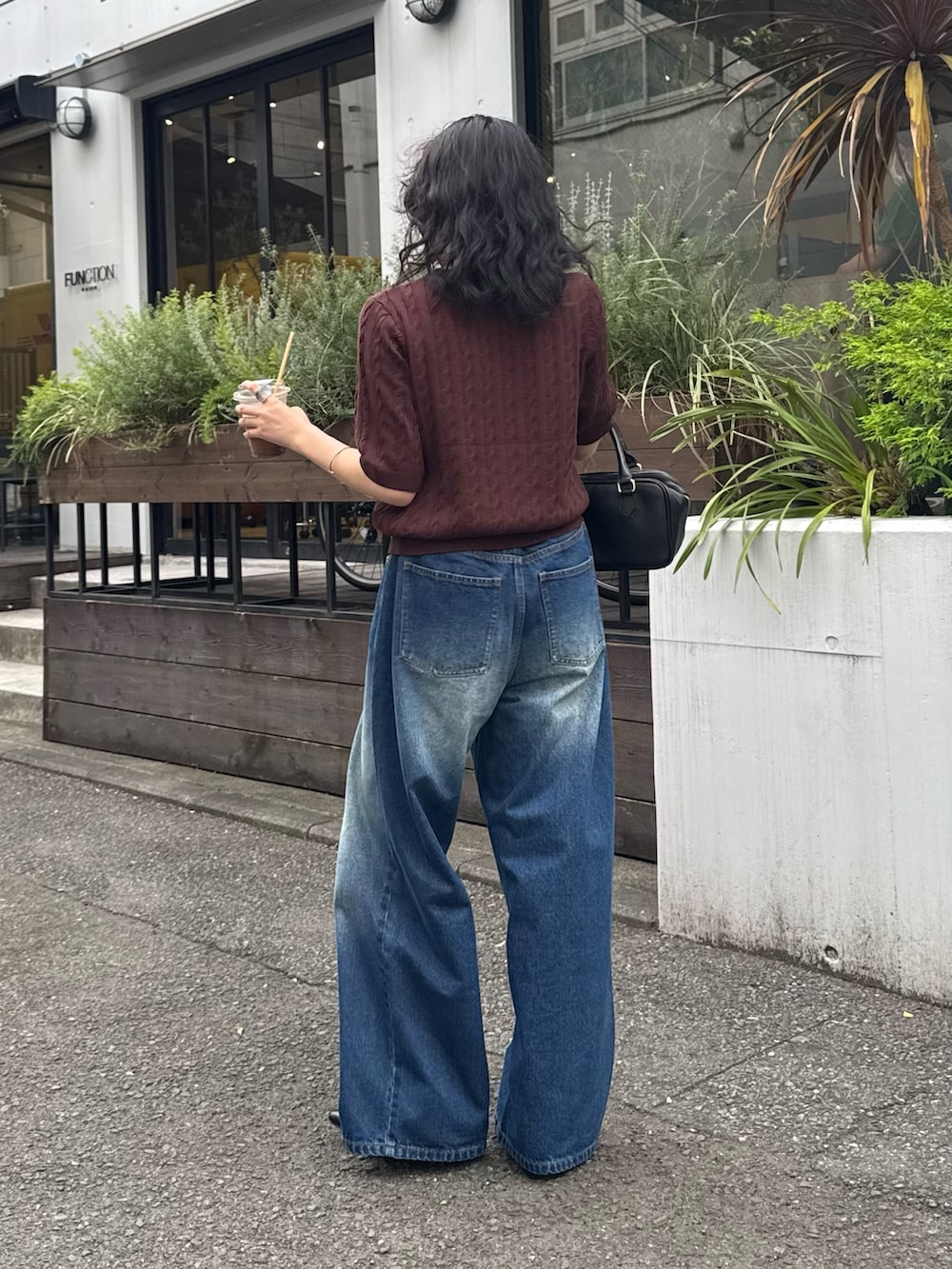 ブラウン系のニット/セーター、ブルー系のデニムパンツ、ブラック系のショルダーバッグを着用したレディースの夏コーディネートの8枚目の写真
