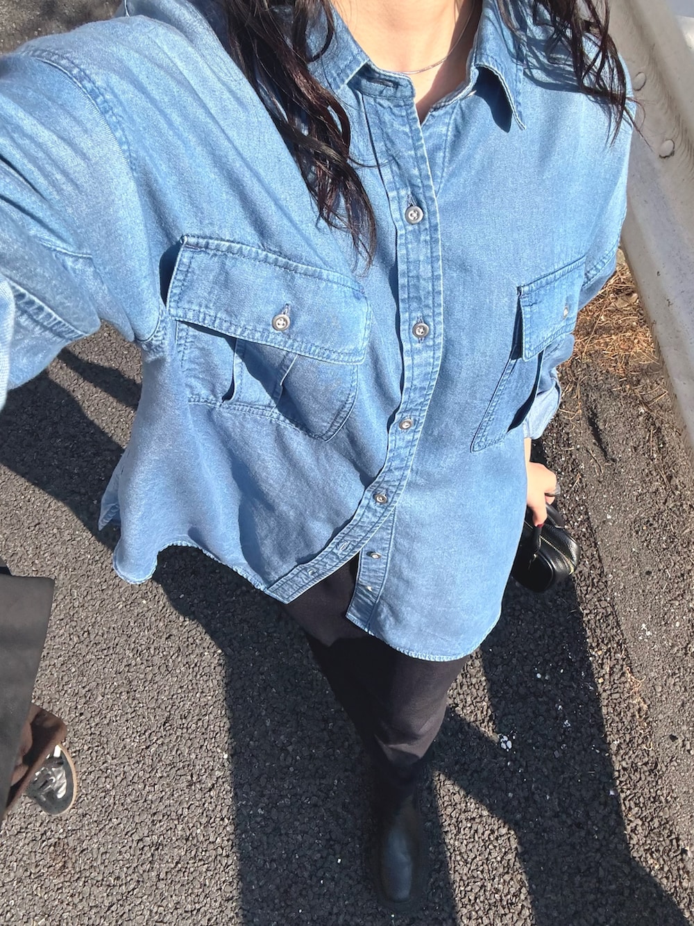 ブルー系のシャツ/ブラウス、ブラック系のスカートを着用したレディースの春コーディネートの7枚目の写真